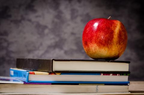 Books stacked with apple on top