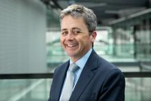 A man in a suit, smiling at the camera