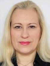 A woman with blonde hair smiles at the camera