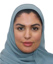 A woman in a blue headscarf smiling at the camera